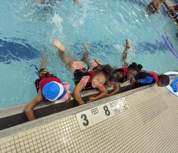 5 children swim together during the Summer LEAP program at the Maplewood Family YMCA