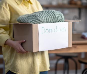 cropped-photo-female-volunteer-holding-carton-full-clothes-prepared-donation.jpg