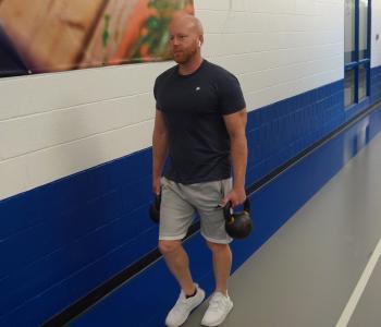 Corning Family YMCA member carrying kettlebell