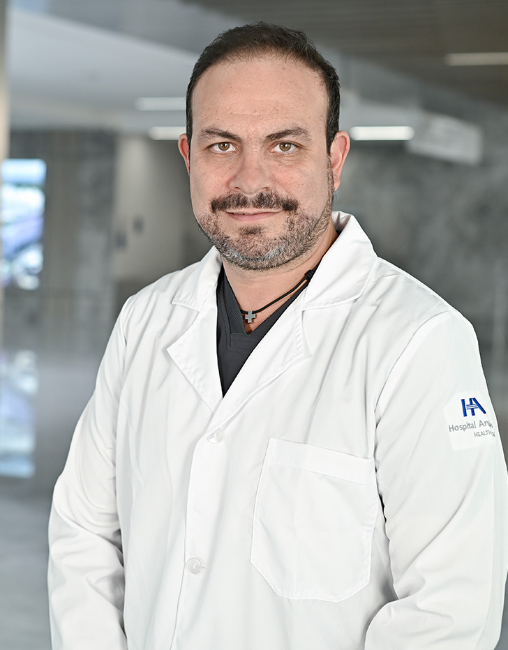 Es la foto de perfil de un urólogo en Querétaro de Hospital Angeles Centro Sur. Usa un uniforme negro y un collar negro con dorado.