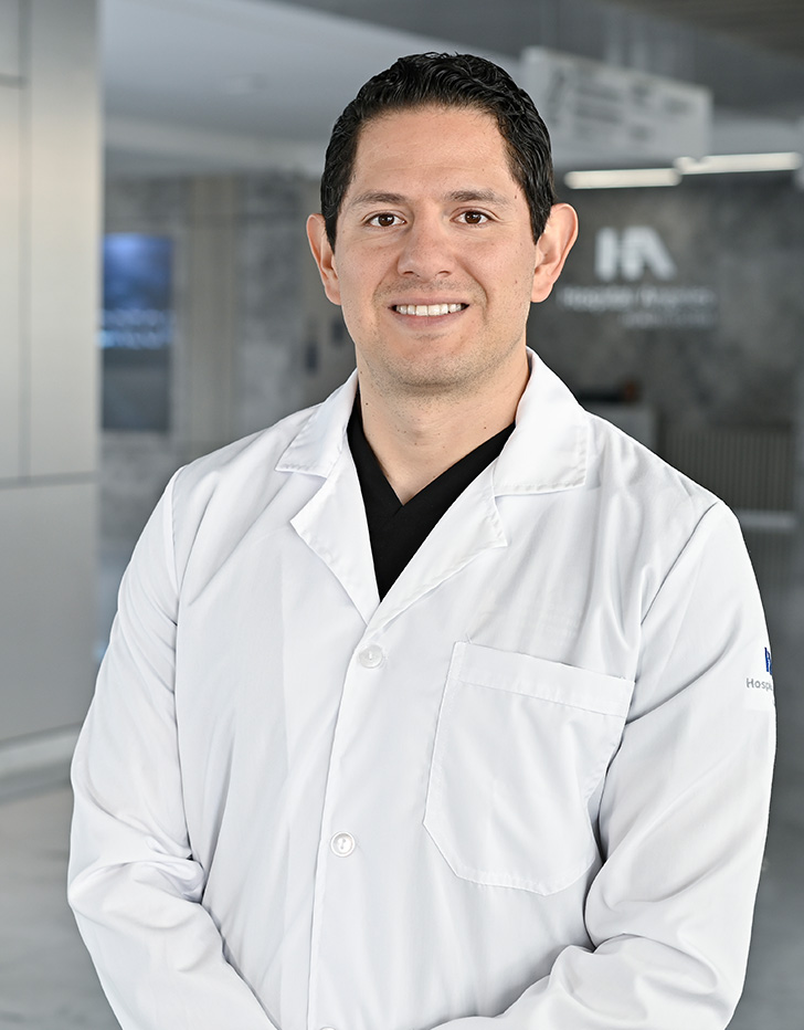 Es la foto de perfil de un urólogo en Querétaro de Hospital Angeles Centro Sur. Usa un uniforme gris, tiene cabello oscuro y ojos grandes.