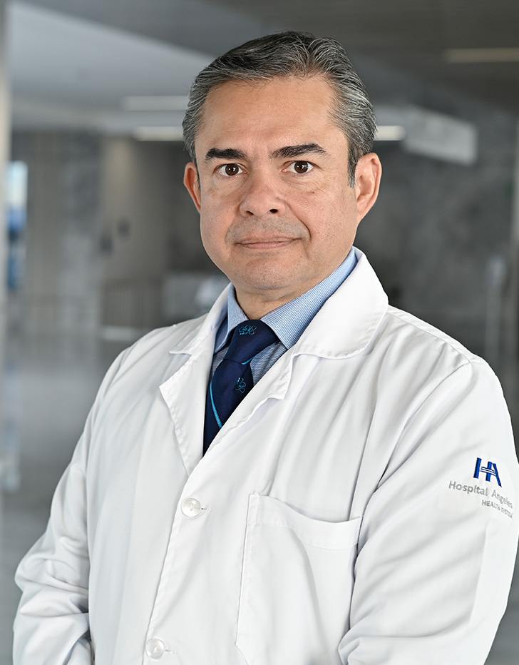 Es la foto de perfil de un cirujano pediátrico en Querétaro de Hospital Angeles Centro Sur. Utiliza un traje azul y una camisa negra, tiene cejas pobladas y cabello canoso.