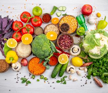 top view of fres foods, spices and vegetables on a white cooking table