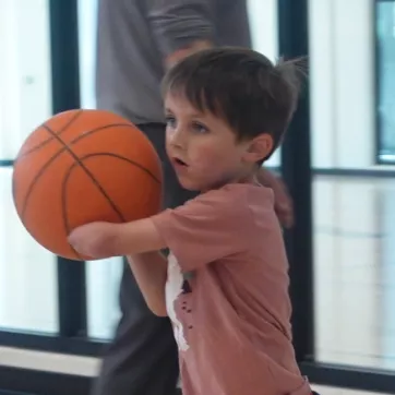 a young member playing basketball 