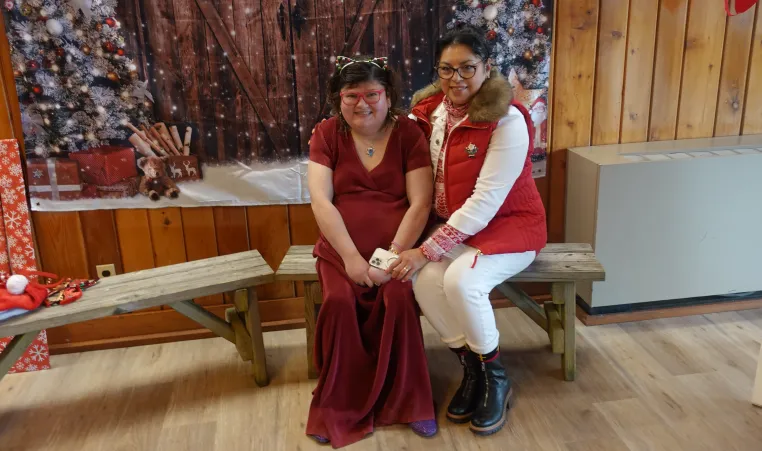 A member and a support staff sitting together at the Winter Wonderland Dance