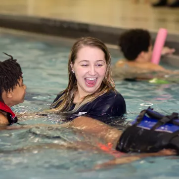 a swim instructor with two kids for swim lessons
