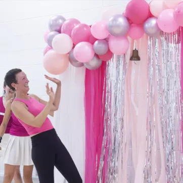 Cathleen Bush rings the4 bell with pink decorations around