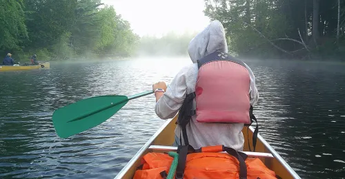 camper holding paddle in boat